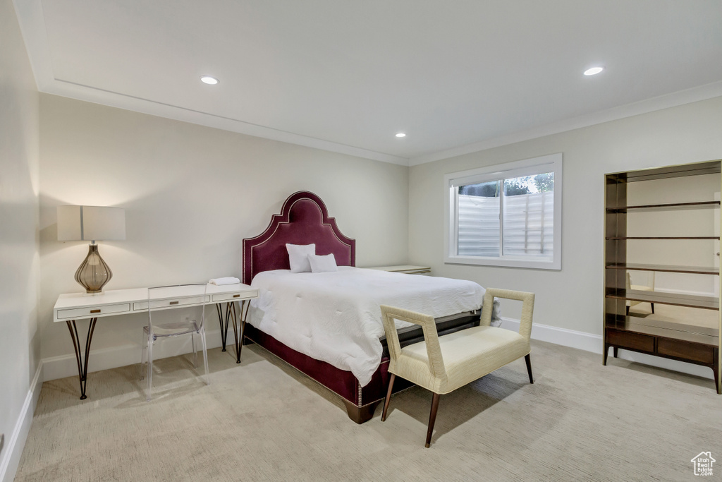 Bedroom with crown molding and light carpet