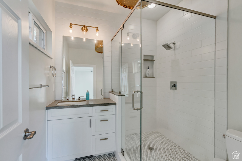 Bathroom featuring vanity, toilet, and an enclosed shower