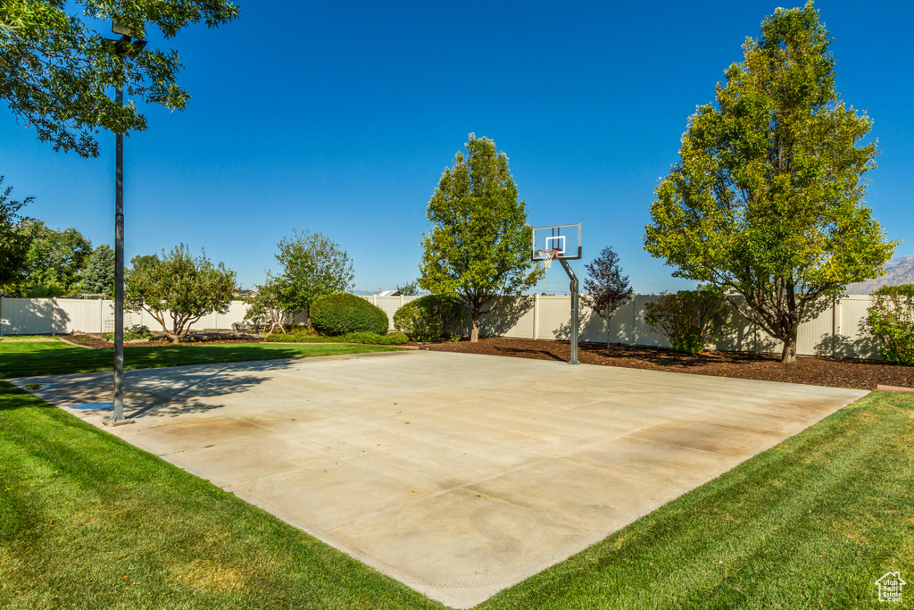 View of sport court with a yard