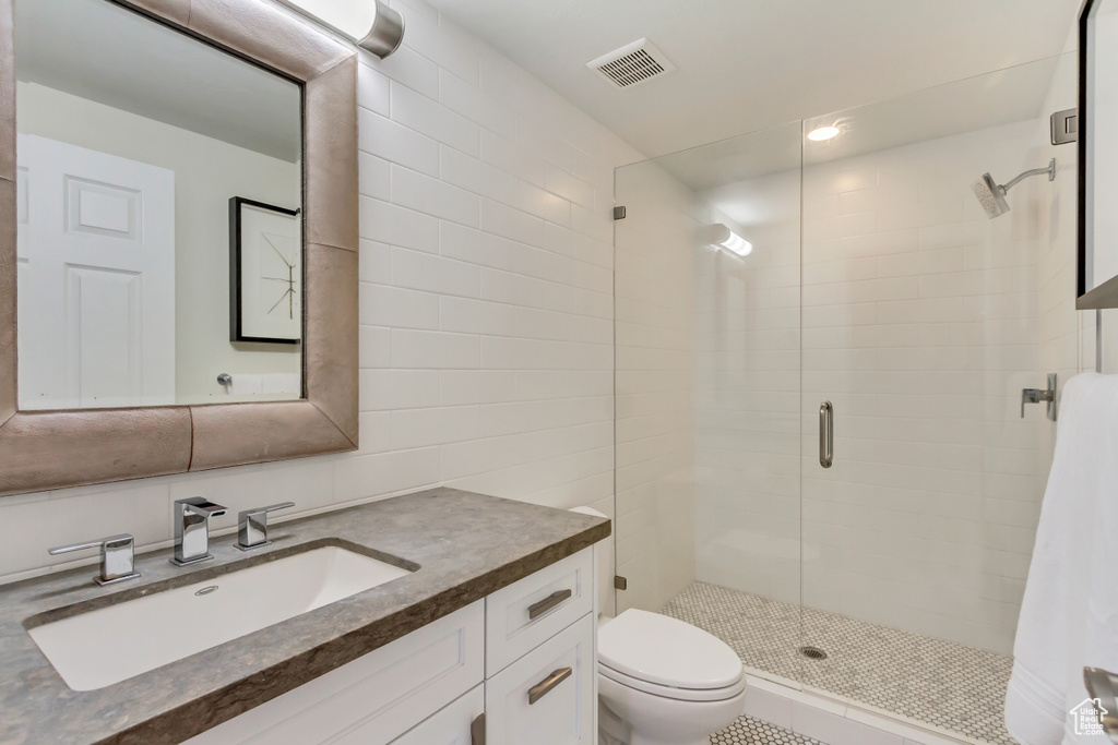 Bathroom with walk in shower, vanity, and toilet