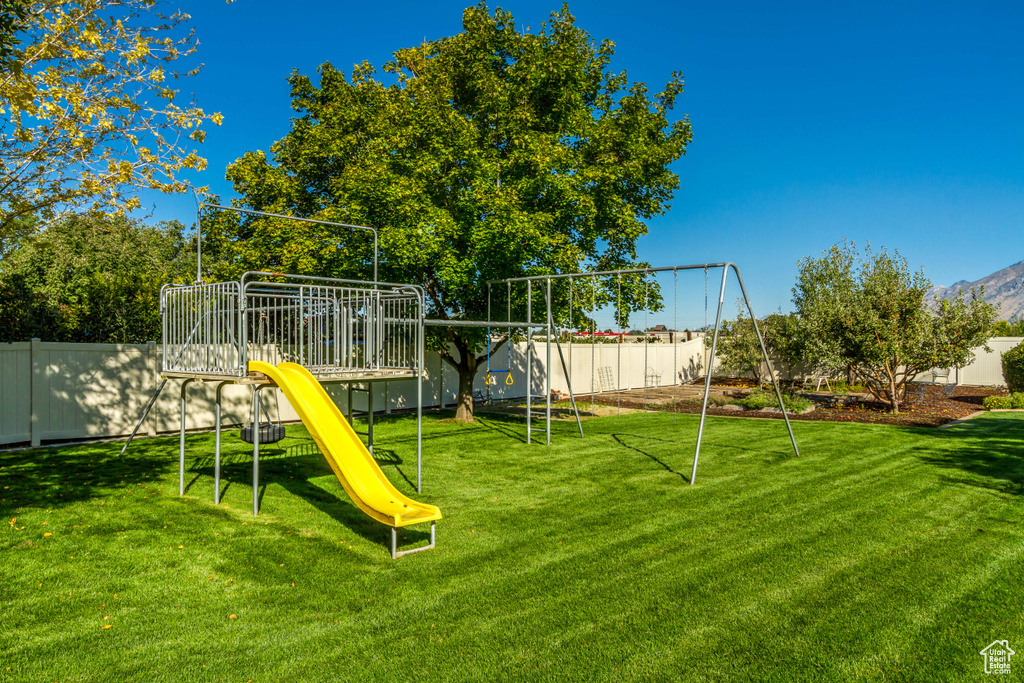 View of jungle gym featuring a lawn