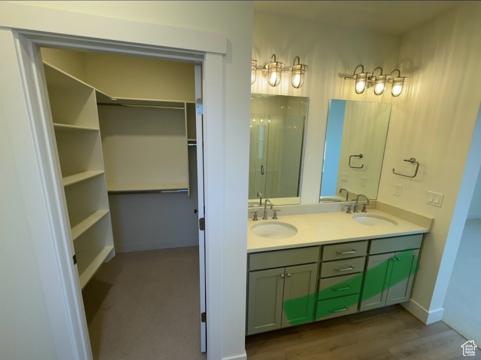 Bathroom featuring wood-type flooring, a shower with shower door, and vanity