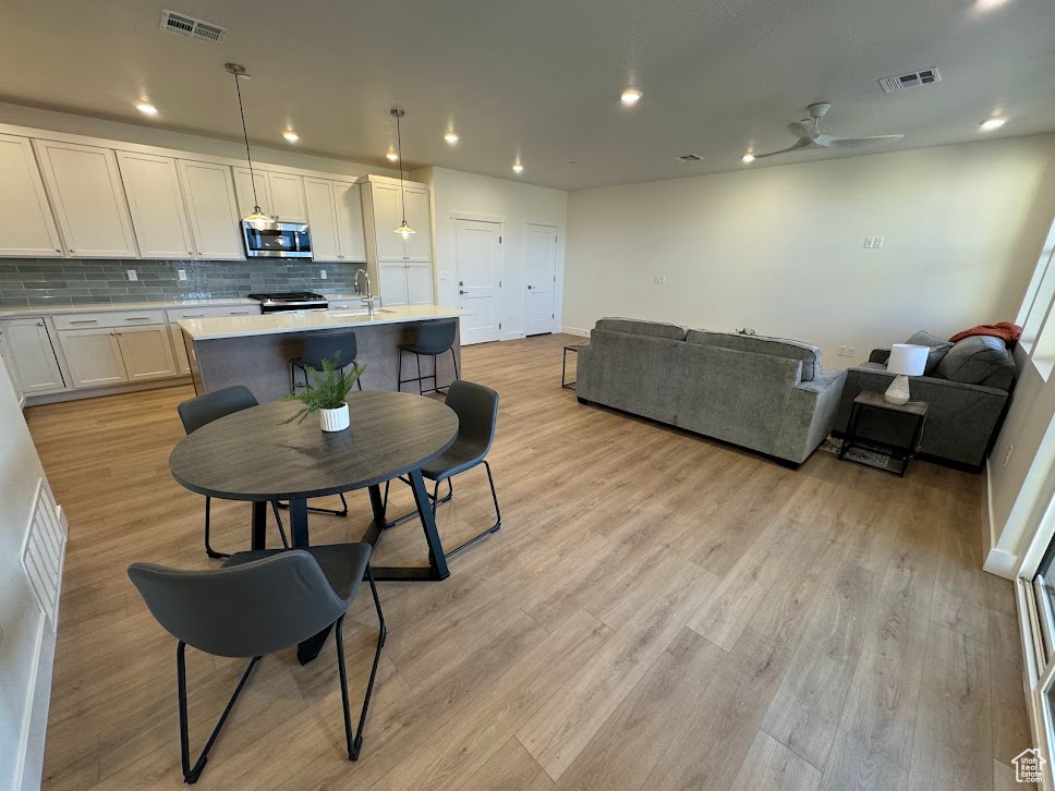 Dining space with light wood-type flooring and ceiling fan