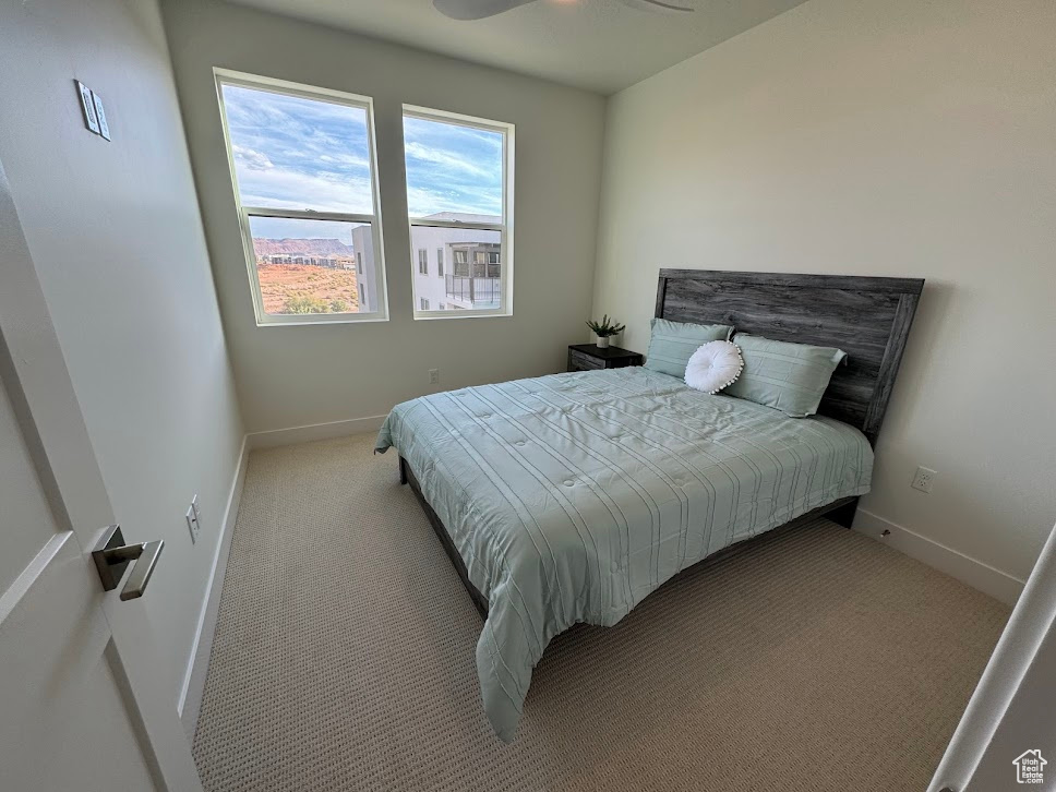 Carpeted bedroom featuring ceiling fan