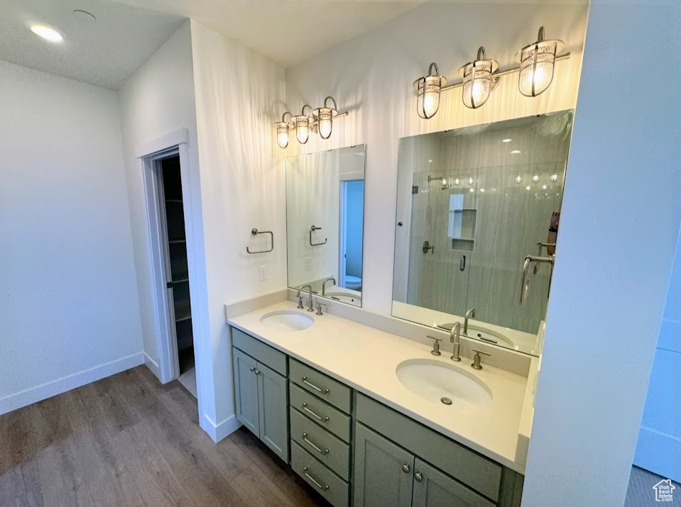 Bathroom featuring wood-type flooring, vanity, and a shower with door