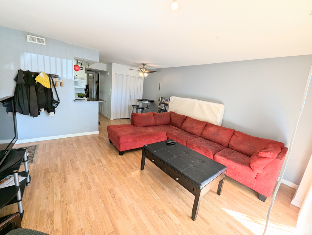 Living room featuring ceiling fan and light wood-type flooring