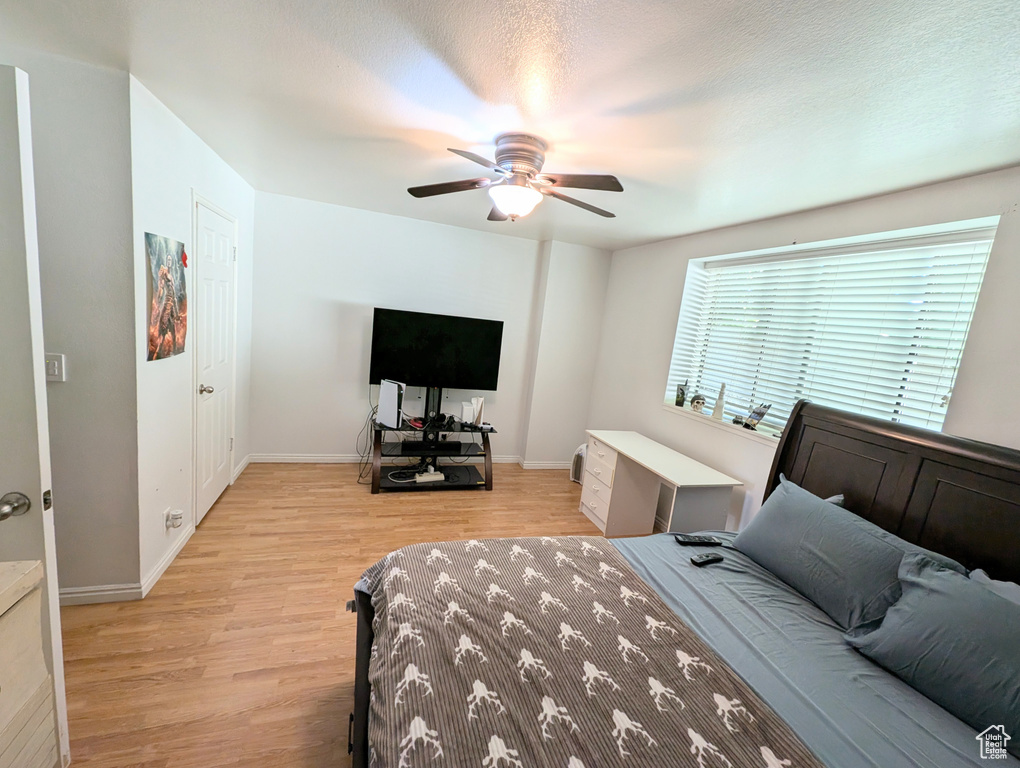 Bedroom featuring ceiling fan, a textured ceiling, and light hardwood / wood-style floors