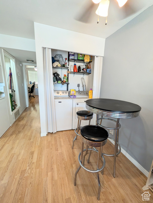 Kitchen featuring ceiling fan, separate washer and dryer, and light hardwood / wood-style flooring
