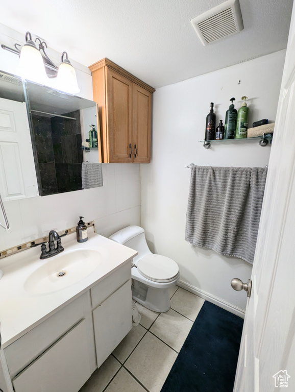 Bathroom with vanity, toilet, and tile patterned floors