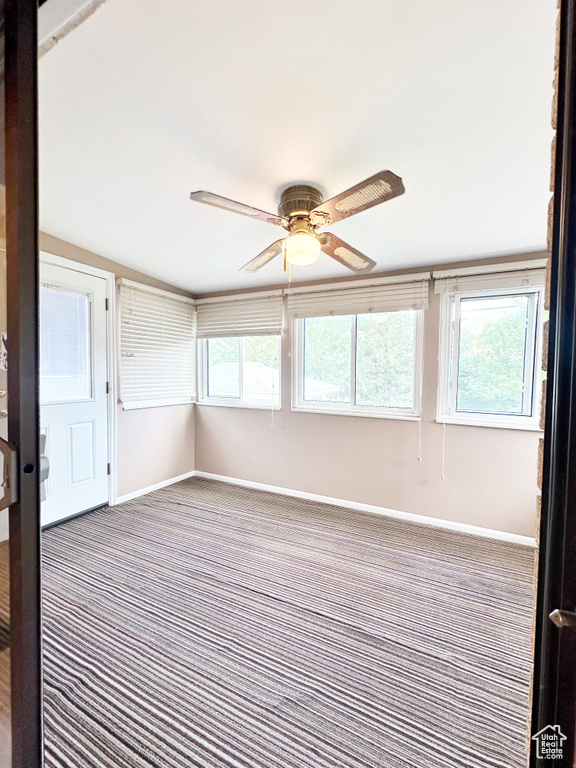 Unfurnished sunroom with ceiling fan and lofted ceiling