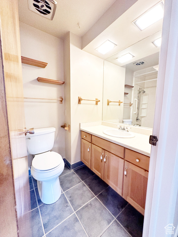 Bathroom featuring tile patterned flooring, vanity, and toilet