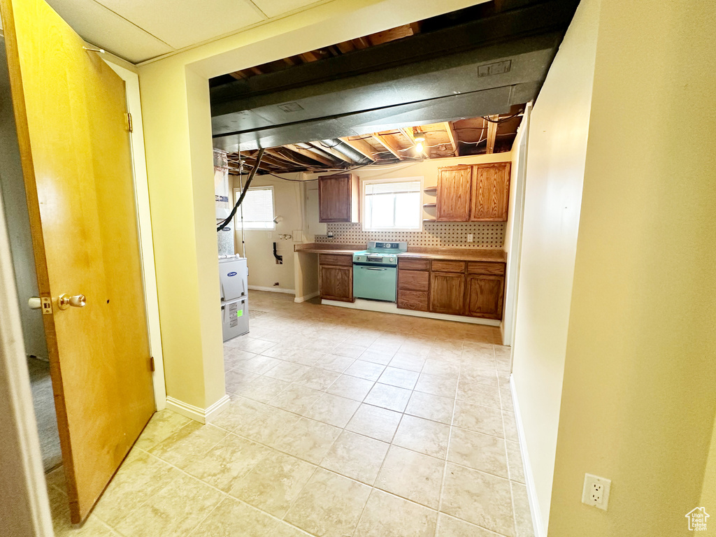 Kitchen featuring backsplash, light tile patterned floors, and stainless steel dishwasher