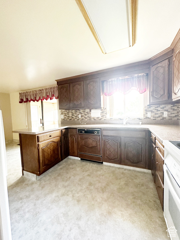 Kitchen featuring light carpet, white oven, dishwasher, and tasteful backsplash