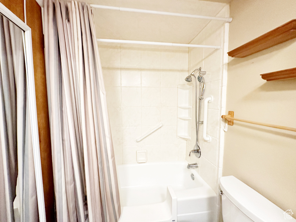 Bathroom featuring shower / bath combo with shower curtain and toilet