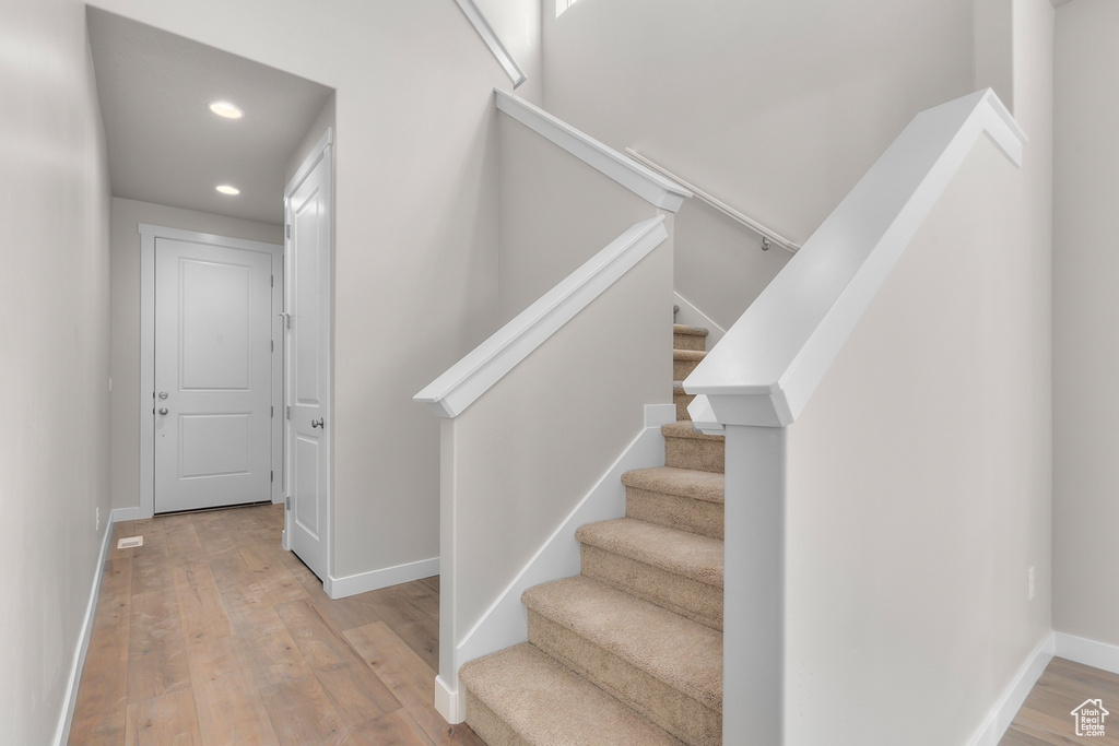 Staircase featuring hardwood / wood-style flooring