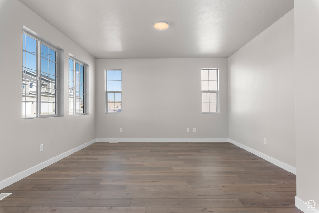 Empty room featuring dark hardwood / wood-style floors