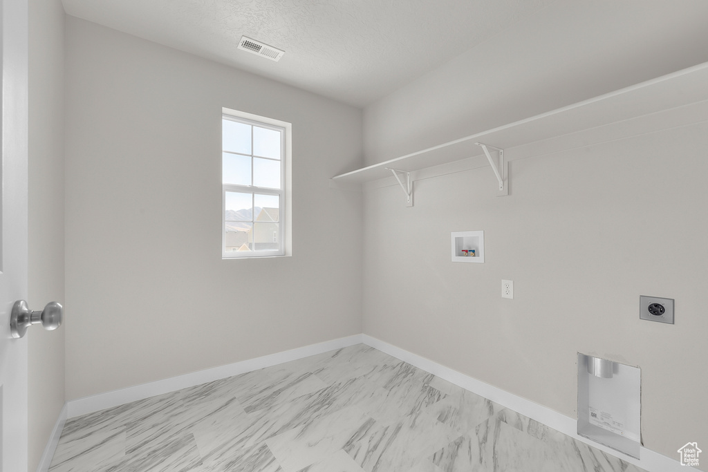 Washroom featuring hookup for a washing machine, a textured ceiling, and electric dryer hookup