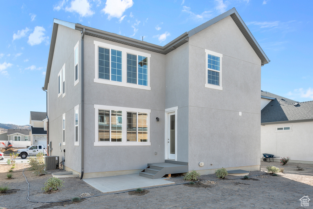 Rear view of property with central air condition unit and a patio area