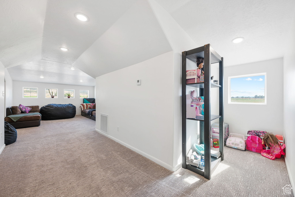 Recreation room featuring vaulted ceiling and carpet flooring