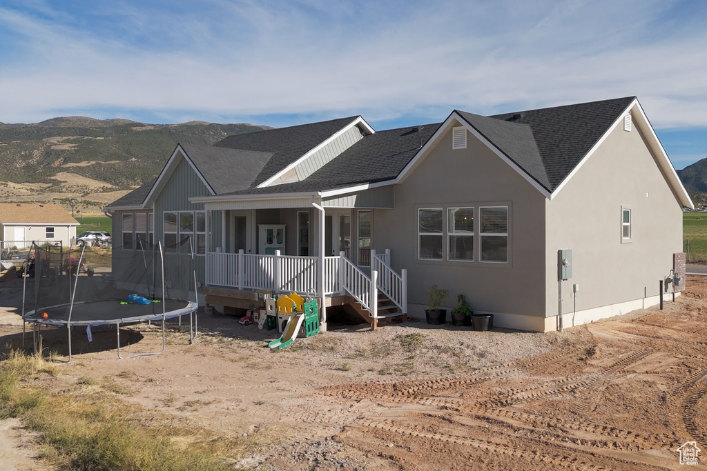 View of front of property with a trampoline and a mountain view