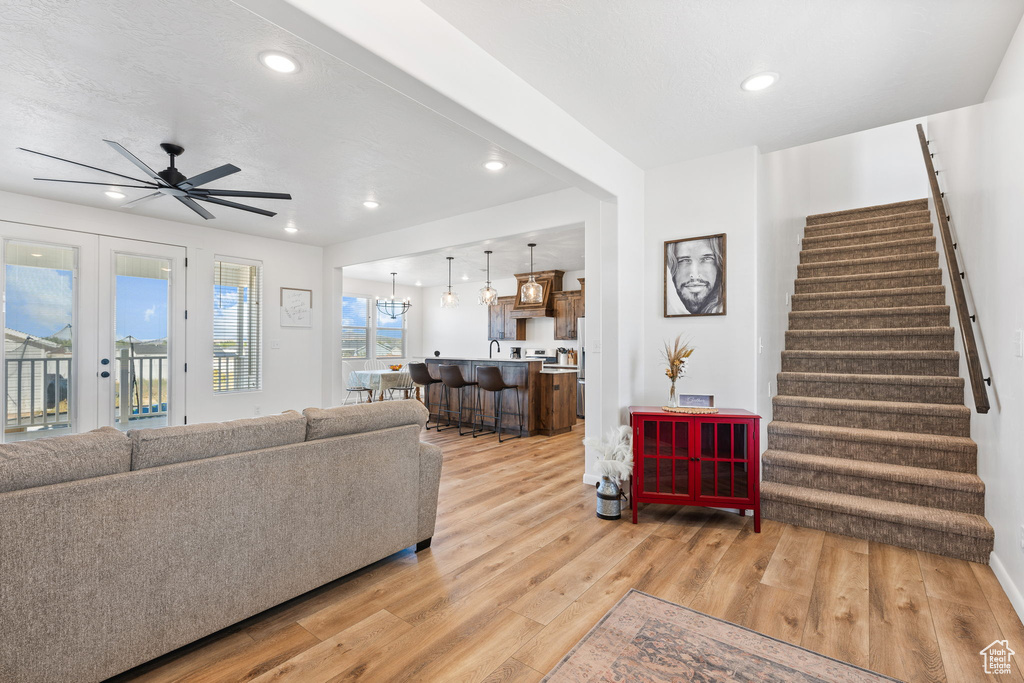 Living room featuring french doors, light hardwood / wood-style floors, and ceiling fan