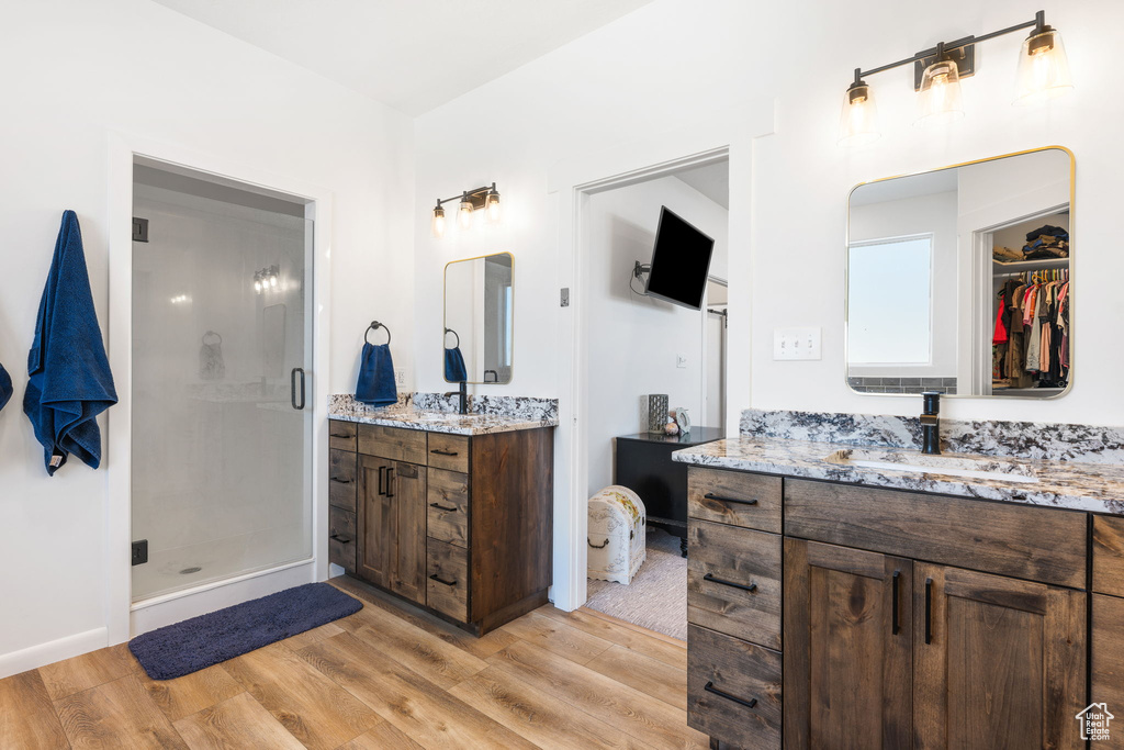 Bathroom featuring vanity, hardwood / wood-style floors, and a shower with door