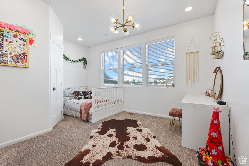 Bedroom with light carpet and a notable chandelier