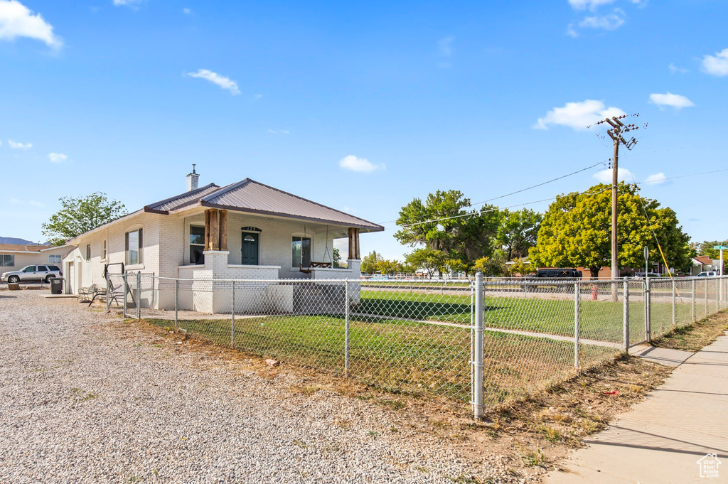 View of front of property with a front yard and covered porch