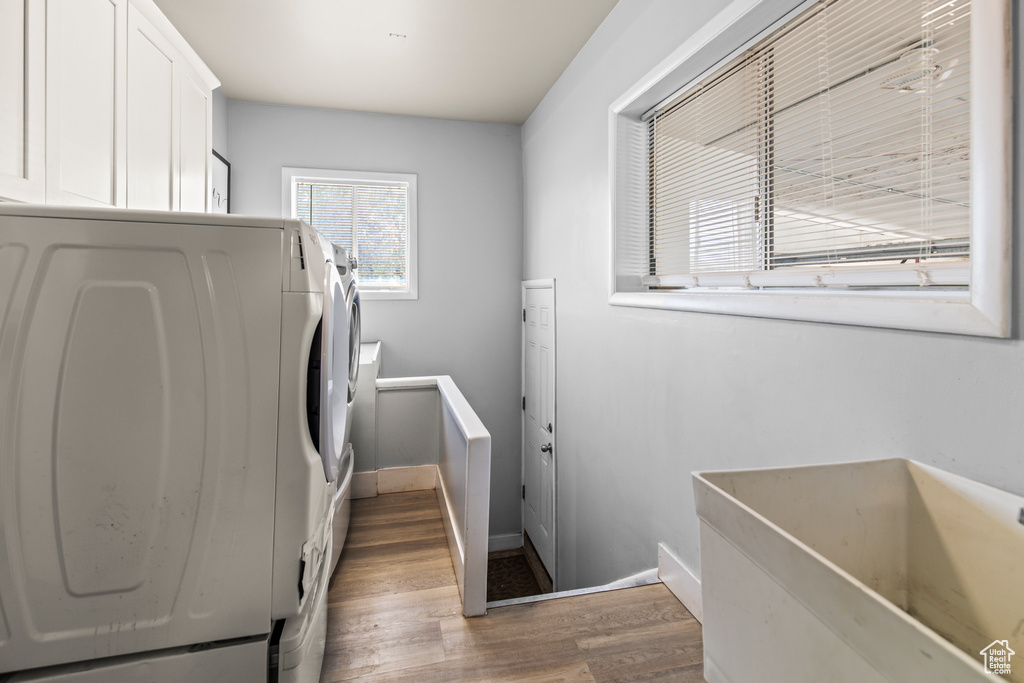 Laundry room featuring separate washer and dryer and hardwood / wood-style floors