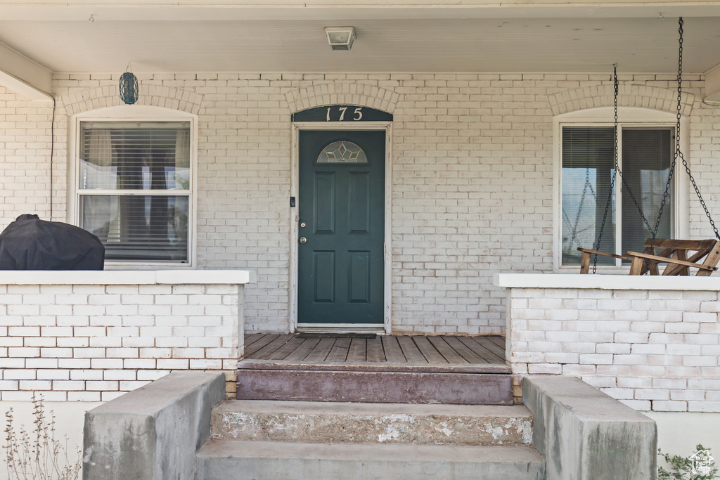 Doorway to property featuring covered porch