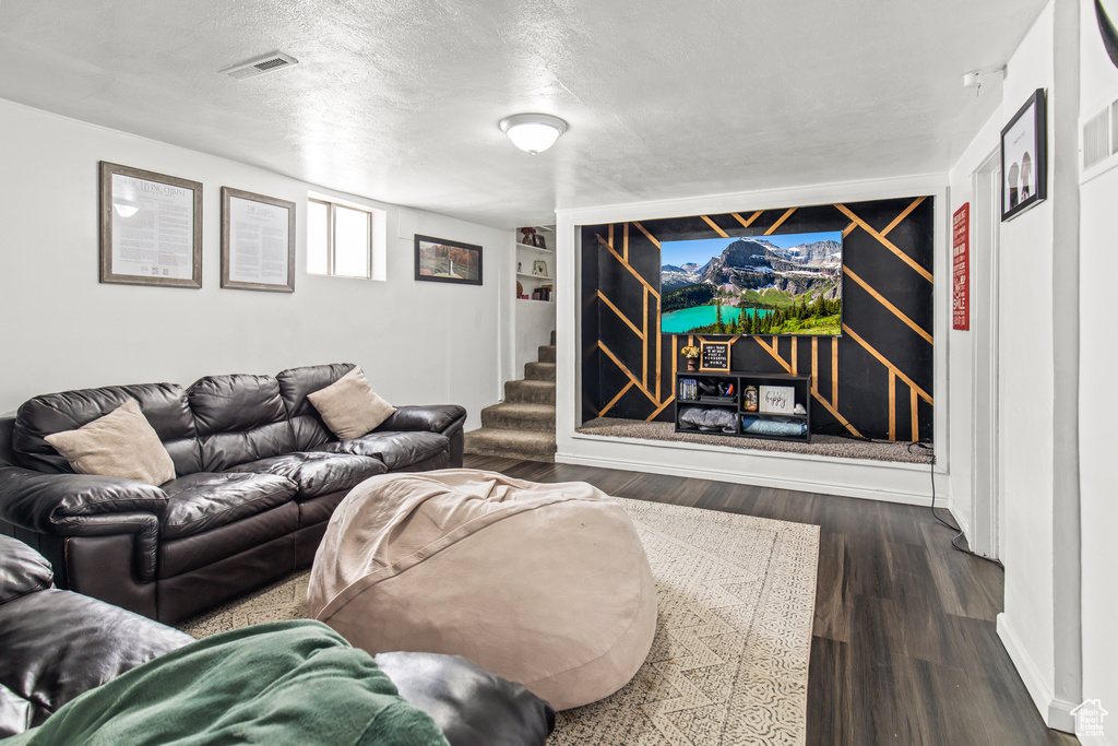 Living room featuring a textured ceiling and dark hardwood / wood-style floors