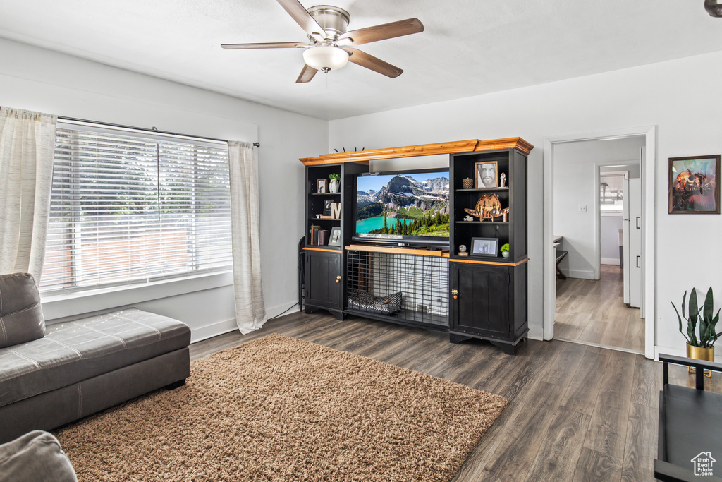 Living room with dark wood-type flooring and ceiling fan