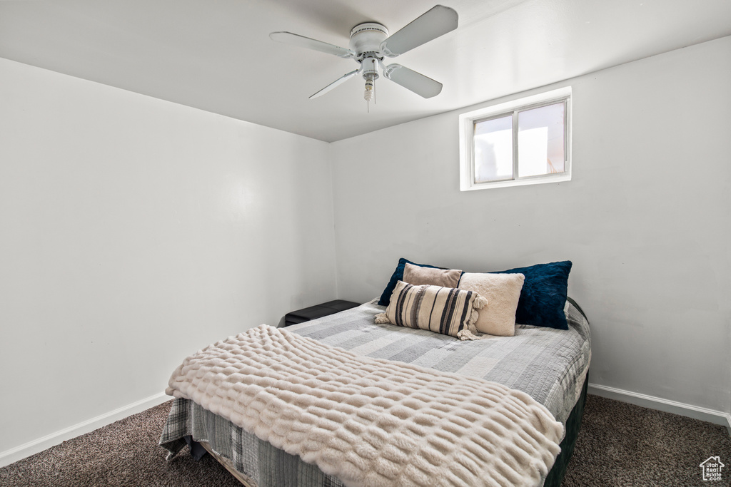 Bedroom with dark carpet and ceiling fan