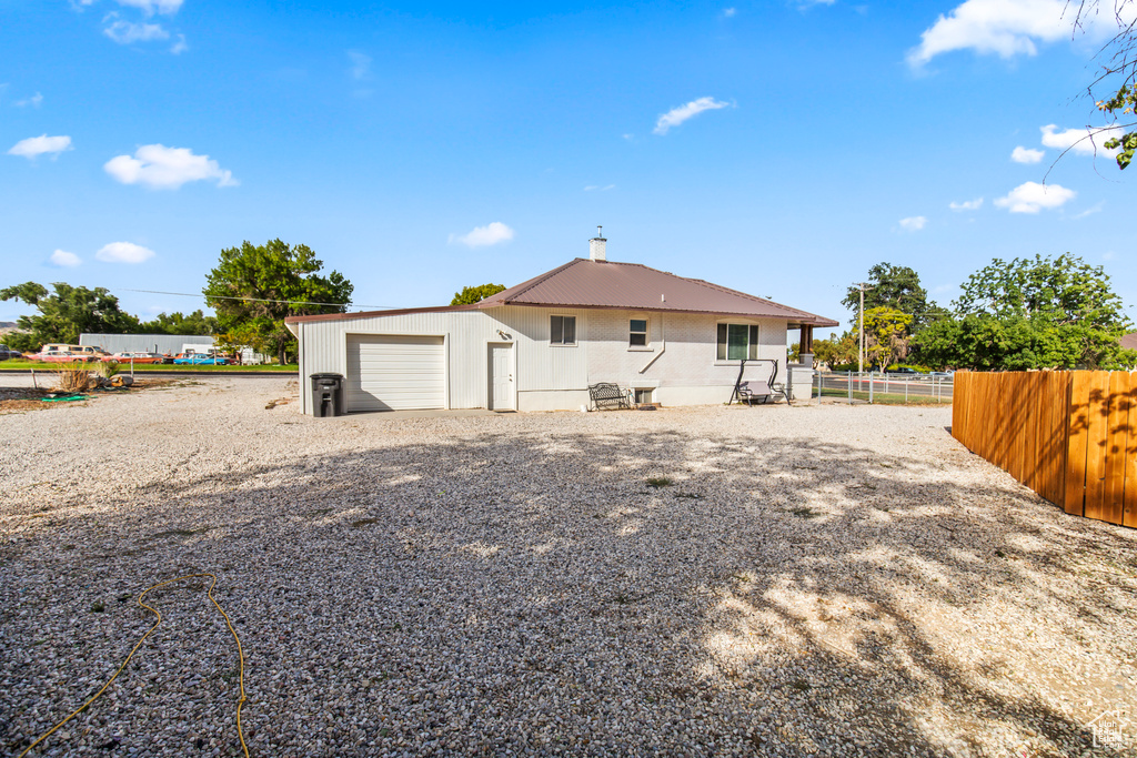 Back of property with an outdoor structure and a garage