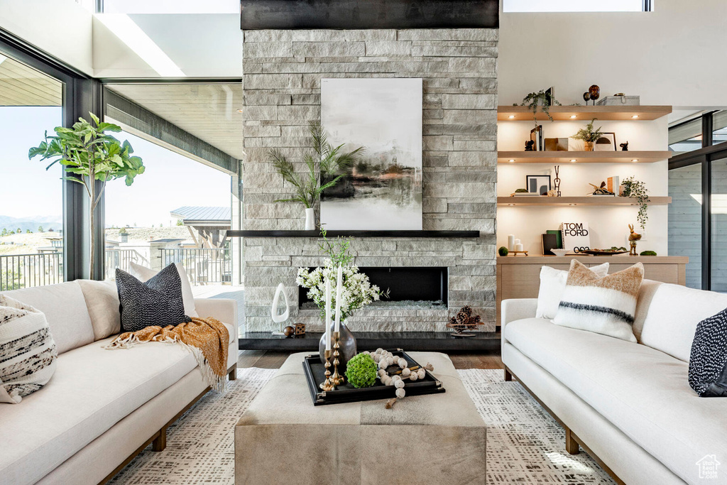 Living room featuring light hardwood / wood-style floors, plenty of natural light, and a stone fireplace