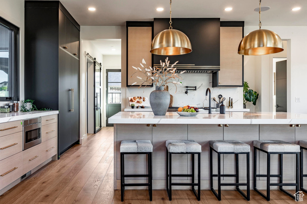 Kitchen featuring a kitchen breakfast bar, wood-type flooring, plenty of natural light, and a barn door