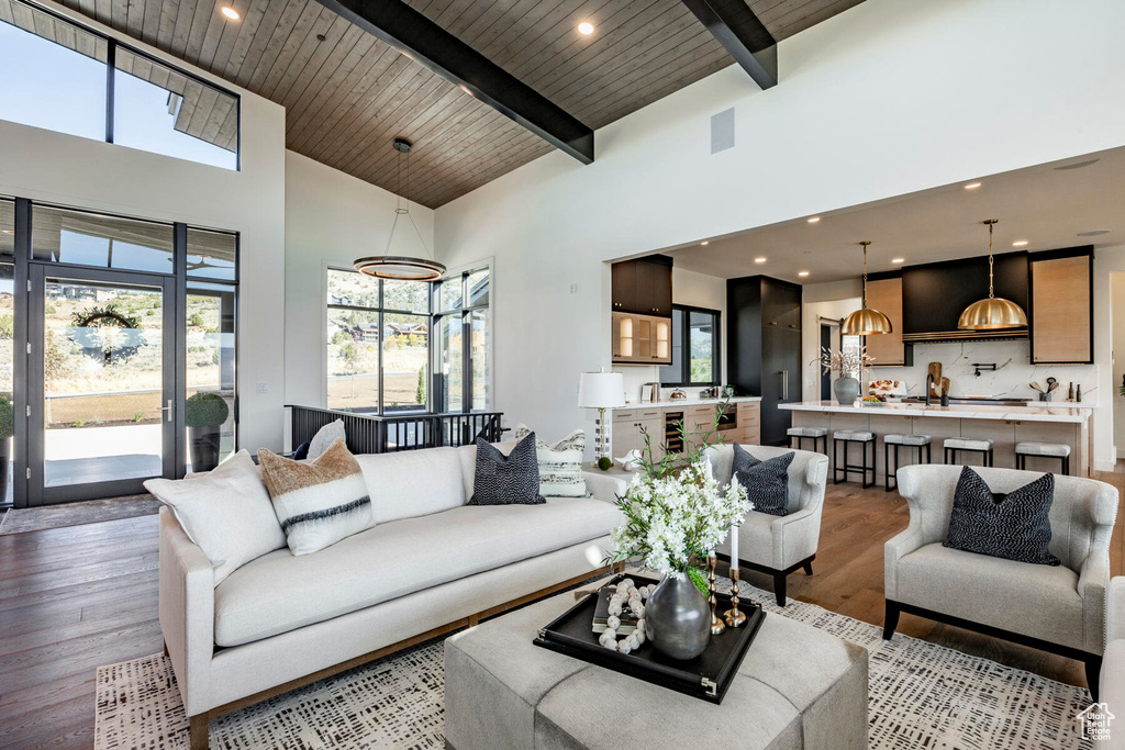 Living room featuring light hardwood / wood-style flooring, a high ceiling, wooden ceiling, and a healthy amount of sunlight