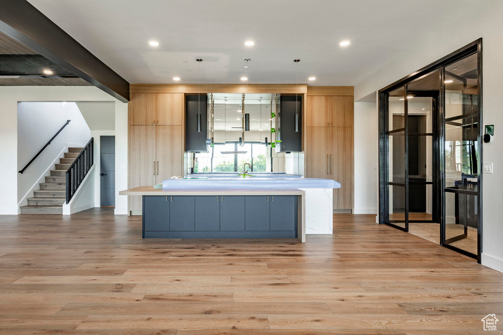 Kitchen featuring beam ceiling, light hardwood / wood-style floors, and a kitchen island