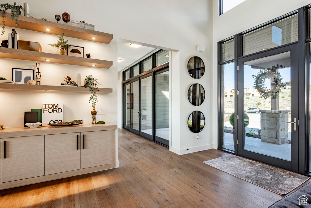 Entryway featuring wood-type flooring and a towering ceiling