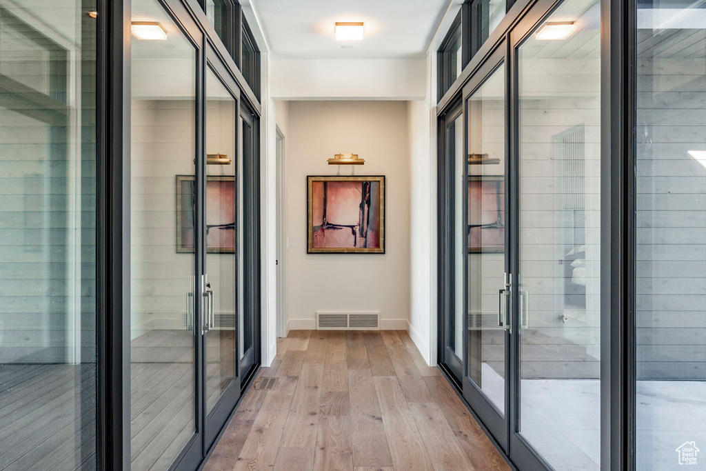 Hallway featuring light hardwood / wood-style flooring and french doors