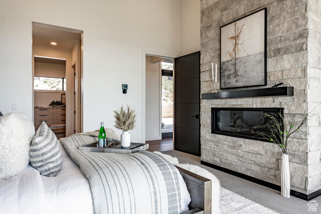 Bedroom featuring carpet floors and a stone fireplace