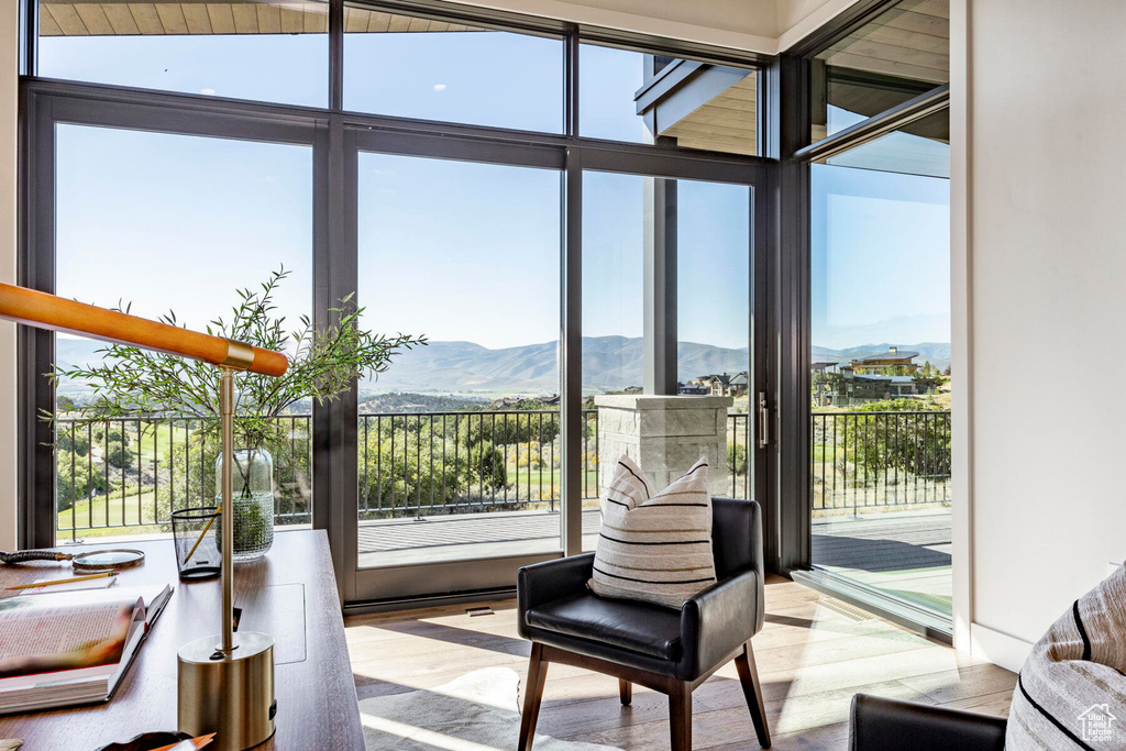 Interior space featuring a healthy amount of sunlight, light hardwood / wood-style floors, vaulted ceiling, and a mountain view