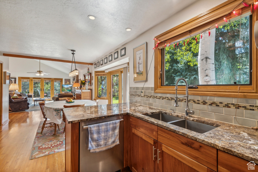 Kitchen with ceiling fan, sink, tasteful backsplash, vaulted ceiling, and light hardwood / wood-style floors