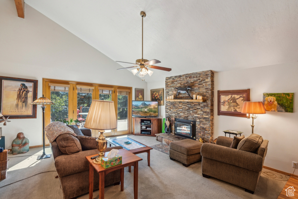 Living room featuring light wood-type flooring, a fireplace, ceiling fan, and high vaulted ceiling