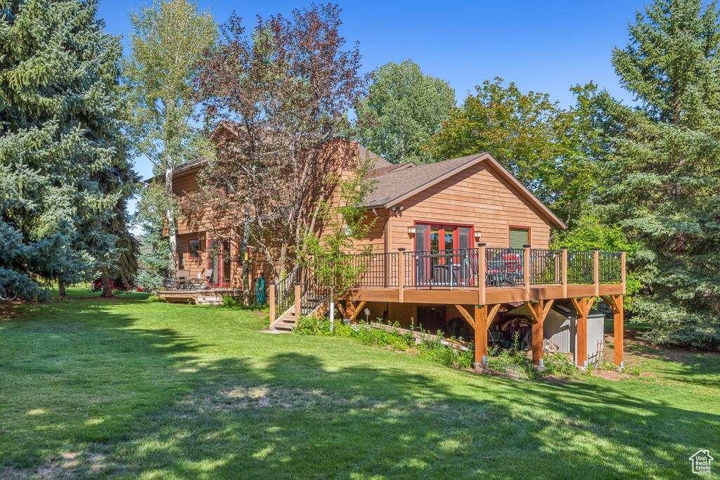 Rear view of property with a wooden deck and a yard