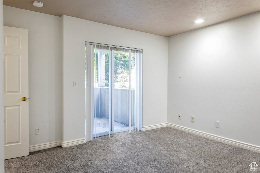 Empty room featuring a textured ceiling and carpet flooring