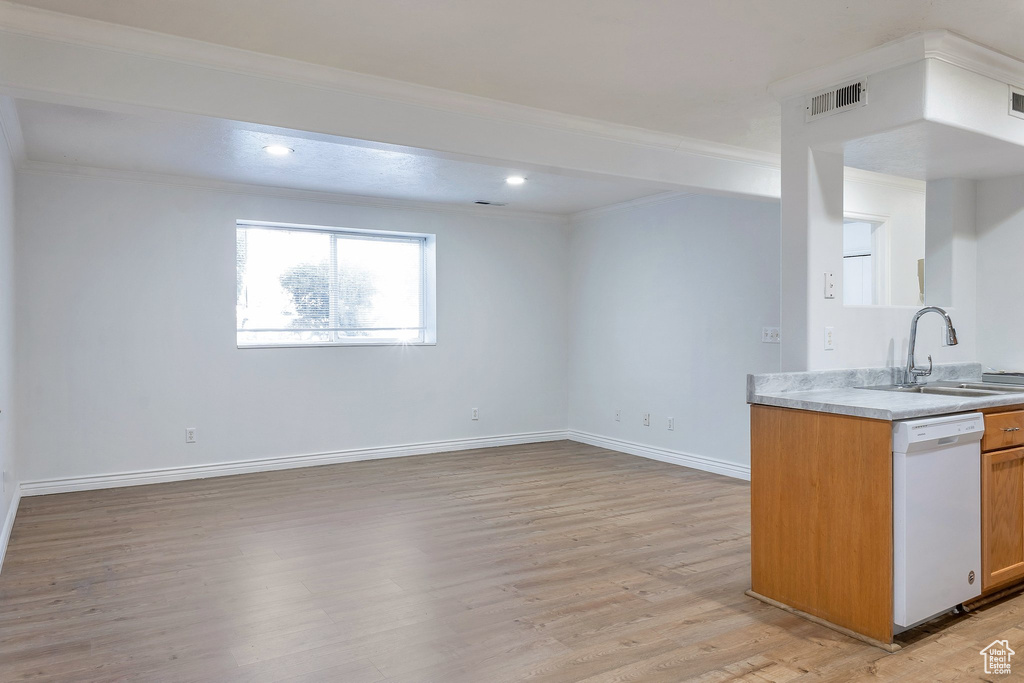 Kitchen with white dishwasher, light hardwood / wood-style flooring, crown molding, and sink