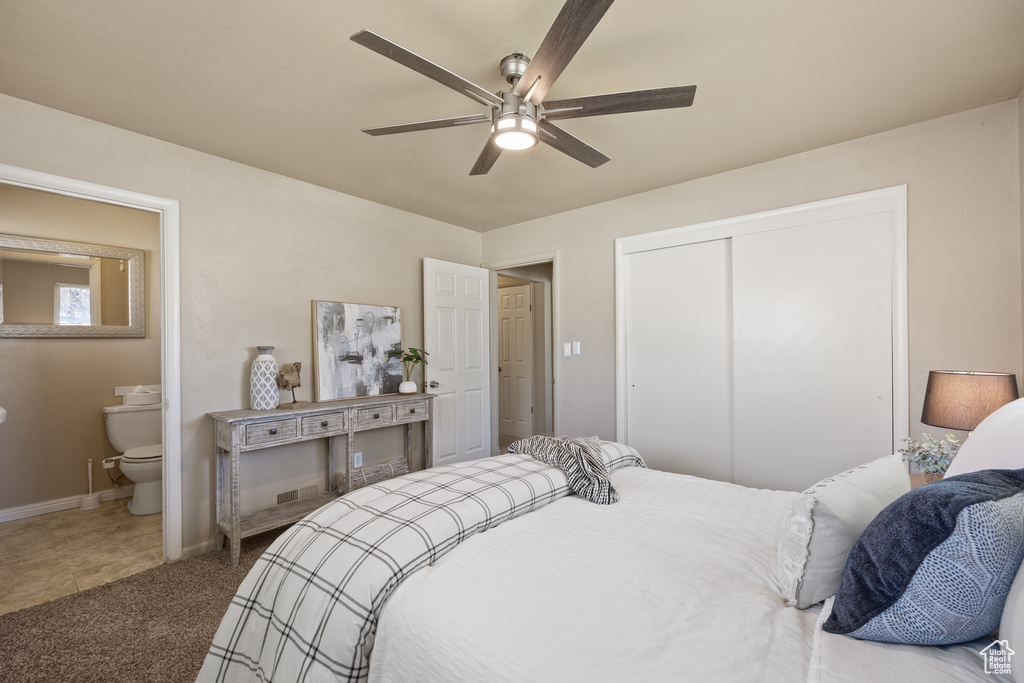 Bedroom with a closet, ceiling fan, ensuite bathroom, and carpet flooring