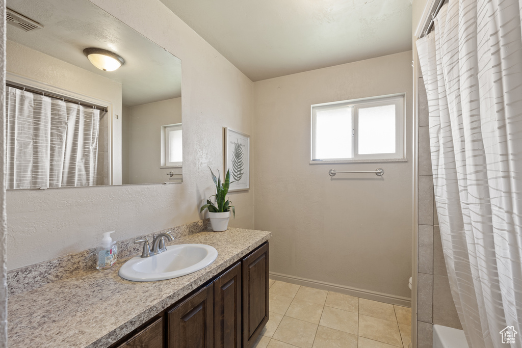 Bathroom featuring vanity, tile patterned floors, and a wealth of natural light