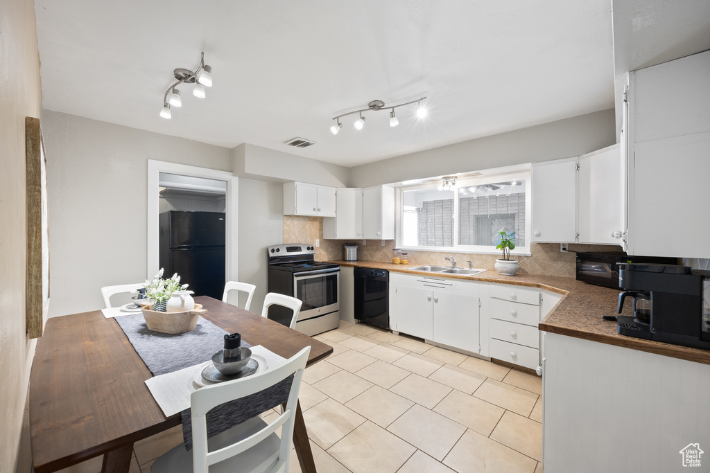 Kitchen with black appliances, white cabinetry, sink, and tasteful backsplash